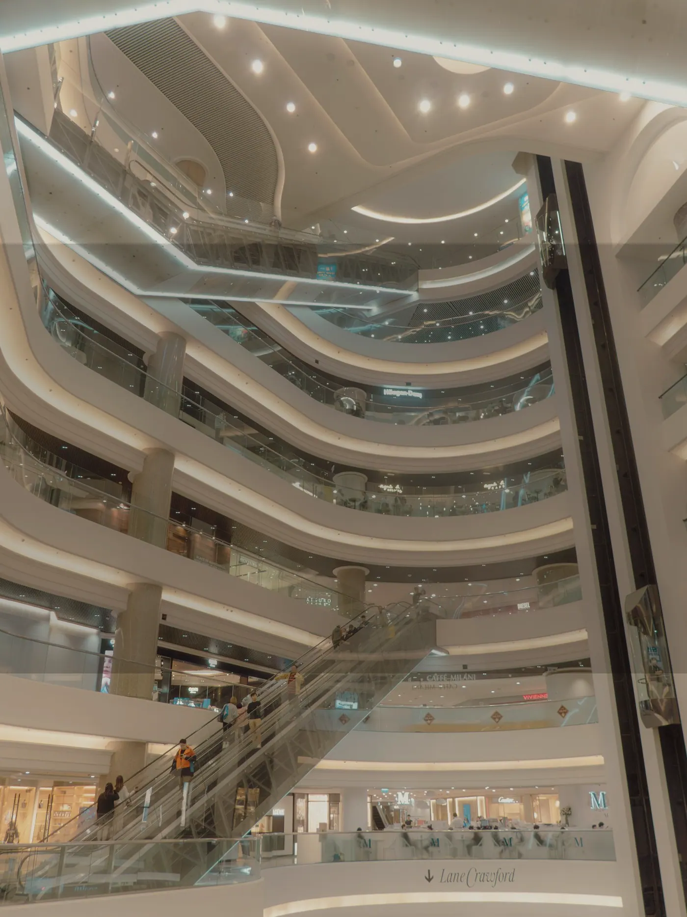 Multilevel shopping mall interior with escalators and open atrium
