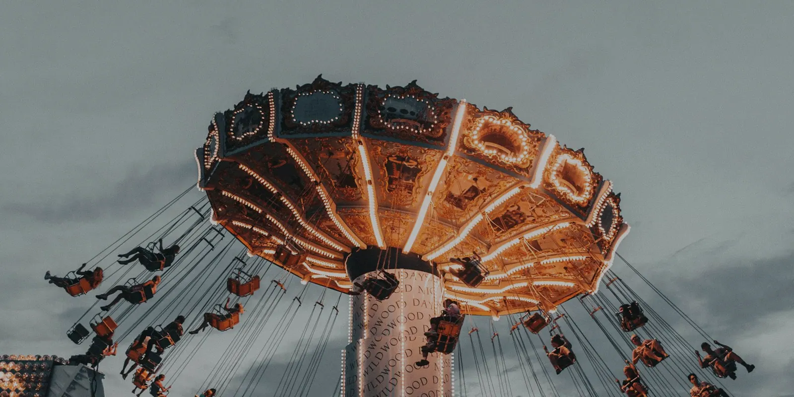 Ferris wheel and crowds at a sunny fairground